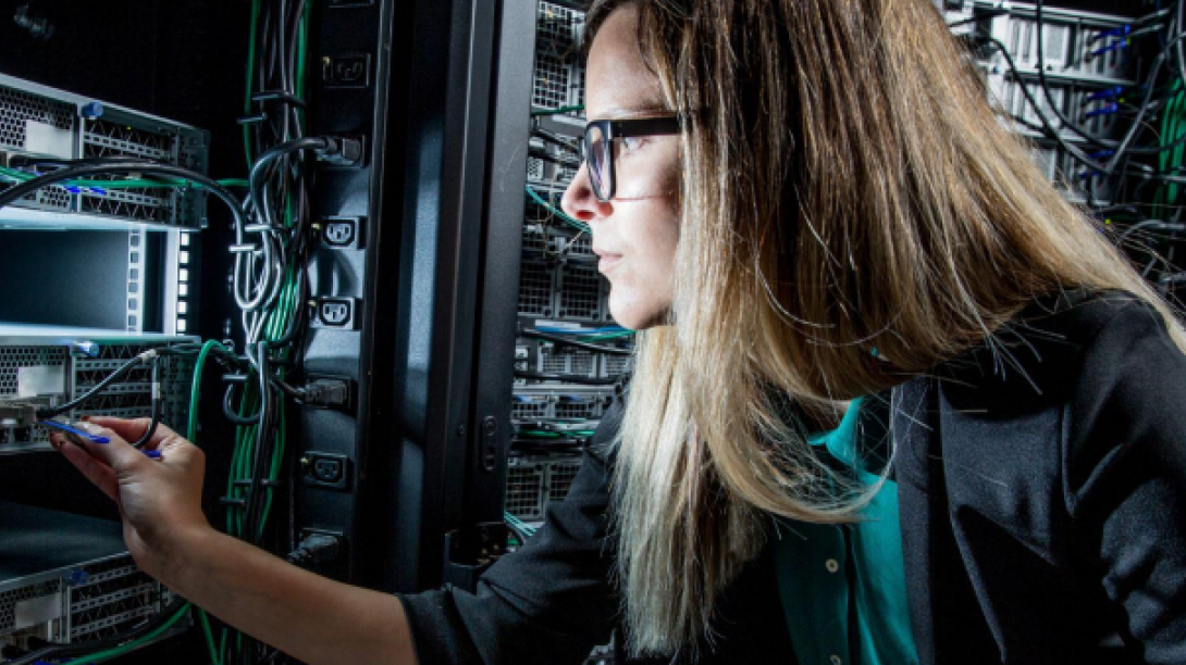 Woman in server room adjusting wire