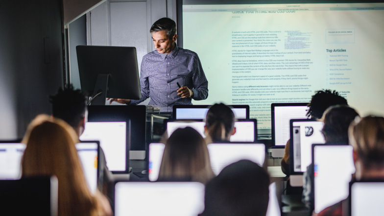 professor leading class with students using computers